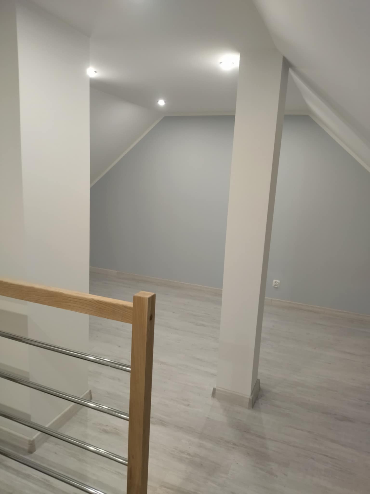 Starannie pomalowane ściany na poddaszu z idealnie wykończonymi skosami i narożnikami